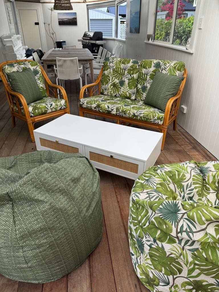 Outdoor patio area with wicker furniture custom made squabs with Monsteras Green Fabric and Artesanal Bean Bag and Cushions.