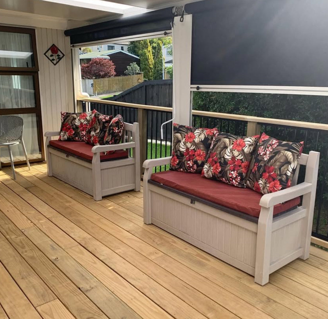 Outdoor furniture set with floral cushions on a wooden deck