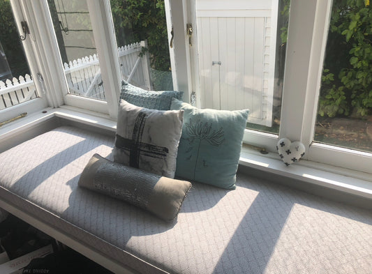 Window seat with cushions in a sunlit room