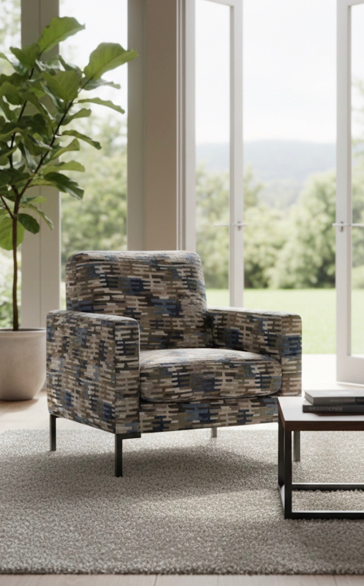 Patterned armchair in a living room with large windows and greenery outside