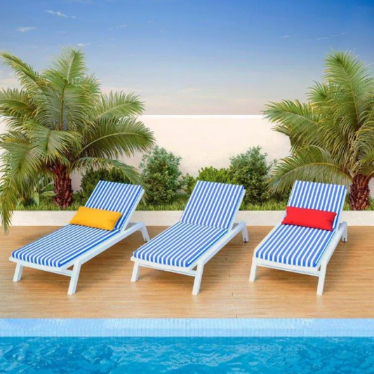 Three striped Waves of Anil sun lounge chairs by a pool with palm trees in the background